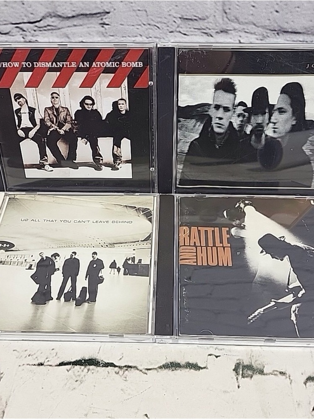 Assorted U2 CD Albums - Black, White and Orange Covers